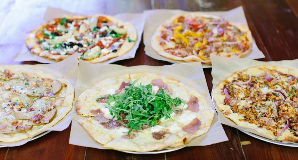 A variety of Red Grape specialty pizzas on the table